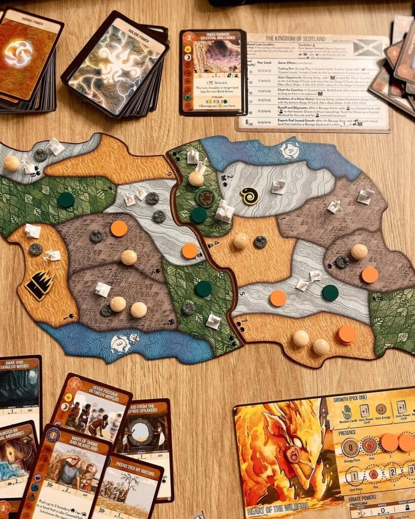 Vedere de sus a unei partide Spirit Island: o tablă-insulă din două panouri cu piese de lemn și jetoane de invadatori, înconjurată de cărți de putere, o fișă de adversar și un panou de spirit al focului.
